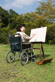 車いすと絵を描く女性